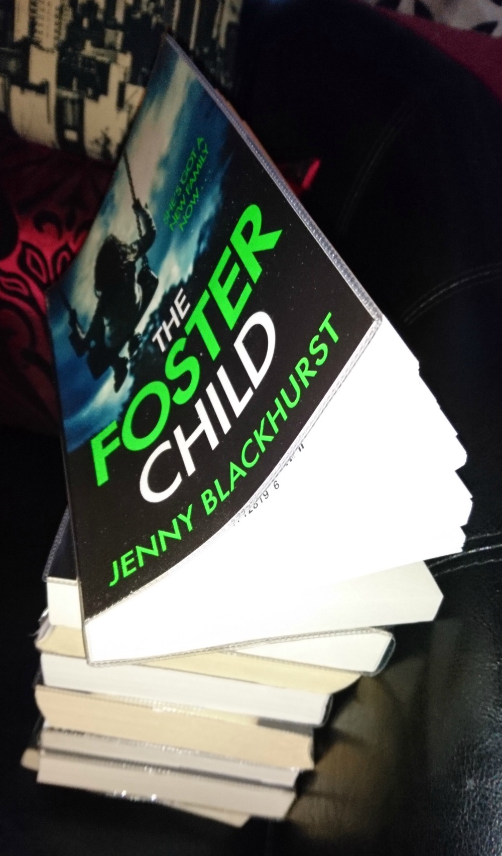 Pile of books topped by The Foster Child by Jenny Blackhurst