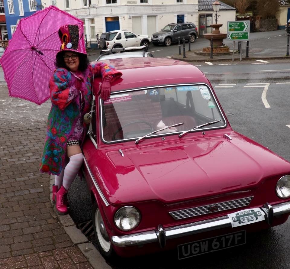 Berni with her car and a pink umbrella