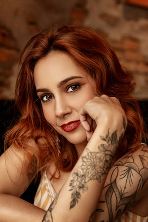 Pretty, red headed lady with tattoos on her arm